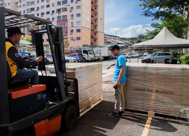 Social Empresa staff unloading a pallet of solar panels at the Kuala Lumpur warehouse